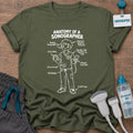 Anatomy of a Sonographer Line Art Male t-shirt with a line-art diagram of a male sonographer in scrubs labeled with “Resting Sonographer Face,” “4th Coffee,” “Full Bladder” and “12,000 Steps”, in Military Green, by Sono Graphics