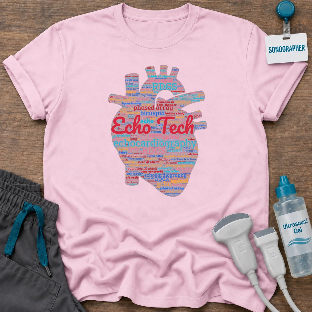 Echo Tech Word Cloud t-shirt with an anatomical heart made of echocardiography words like apical, bicuspid, RDCS and phased array, with “Echo Tech” in red, in Light Pink, by Sono Graphics