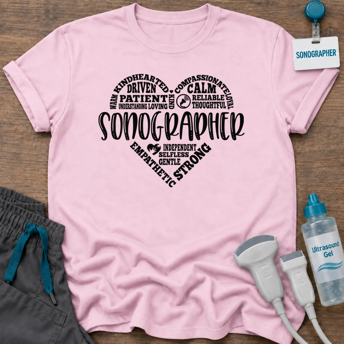 Sonographer's Heart t-shirt with a heart made of words like patient, calm, compassionate and strong around SONOGRAPHER, in Light Pink, by Sono Graphics