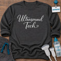 Ultrasound Tech Elegant Script Heart sonographer sweatshirt with Ultrasound Tech in flowing script and a small heart, in Dark Heather, by Sono Graphics