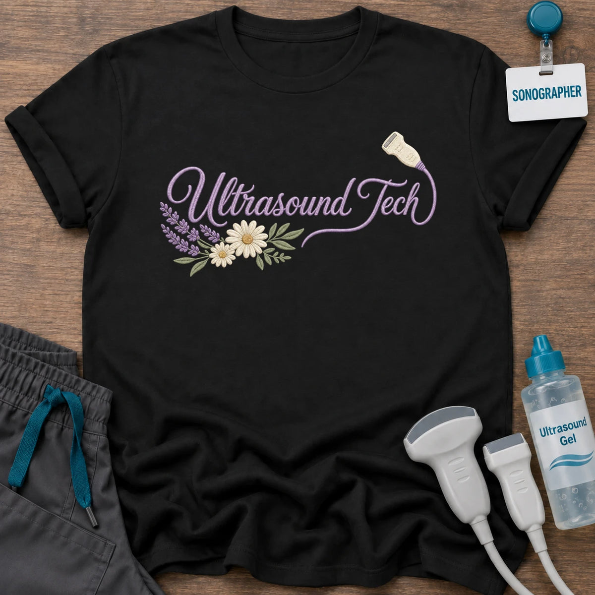Floral Ultrasound Tech t-shirt with “Ultrasound Tech” in lavender script ending in a transducer, with daisies and lavender sprigs, in Black, by Sono Graphics