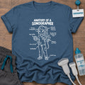 Anatomy of a Sonographer Line Art t-shirt with a line-art diagram of a female sonographer in scrubs labeled with “Resting Sonographer Face,” “4th Coffee,” “Full Bladder” and “12,000 Steps”, in Indigo Blue, by Sono Graphics