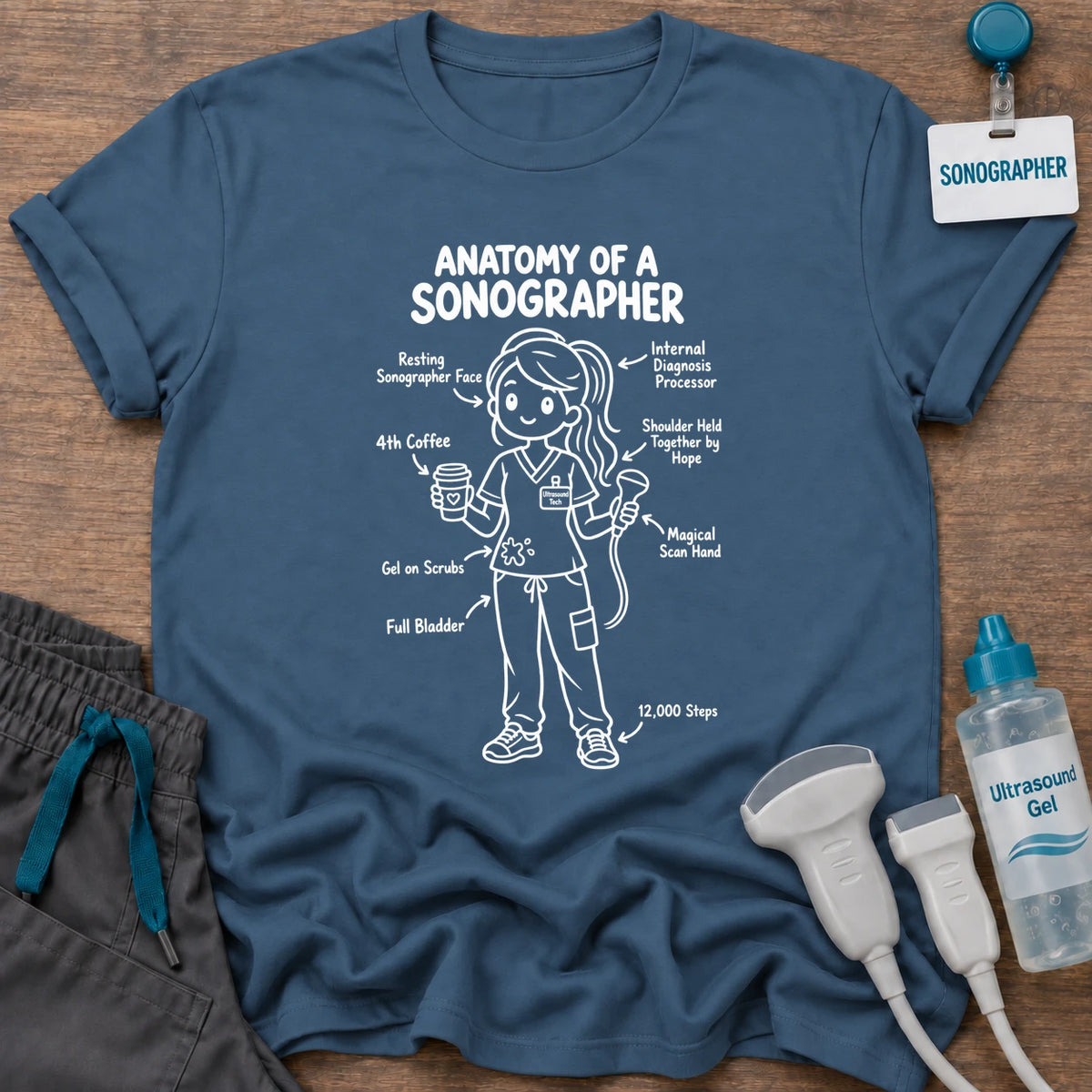 Anatomy of a Sonographer Line Art t-shirt with a line-art diagram of a female sonographer in scrubs labeled with “Resting Sonographer Face,” “4th Coffee,” “Full Bladder” and “12,000 Steps”, in Indigo Blue, by Sono Graphics
